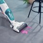 Leifheit Akku-Saugwischer Regulus Aqua PowerVac in Aktion, reinigt rosa Flüssigkeit auf Fliesen.