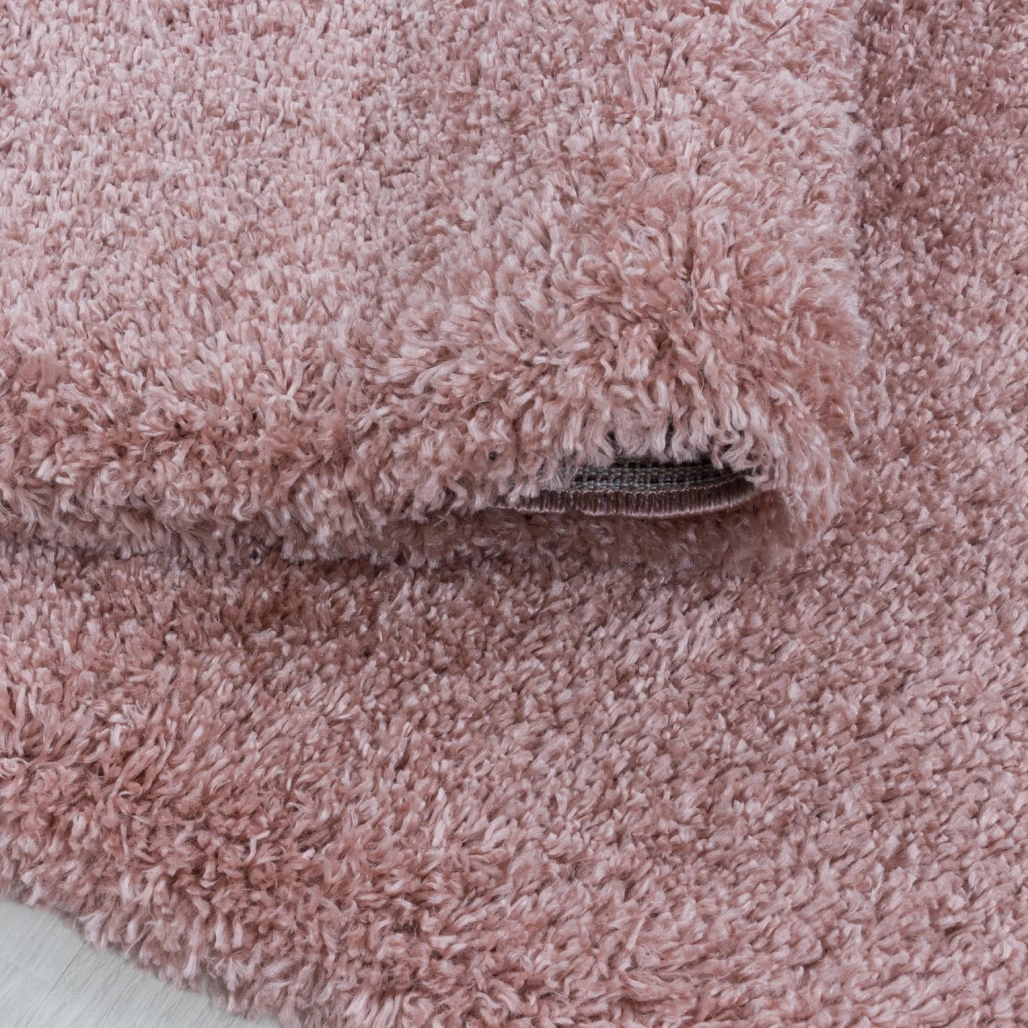 Rosa Hochflorteppich (Ø 120 cm) mit flauschiger Textur. Shaggy Teppich für Wohnräume.