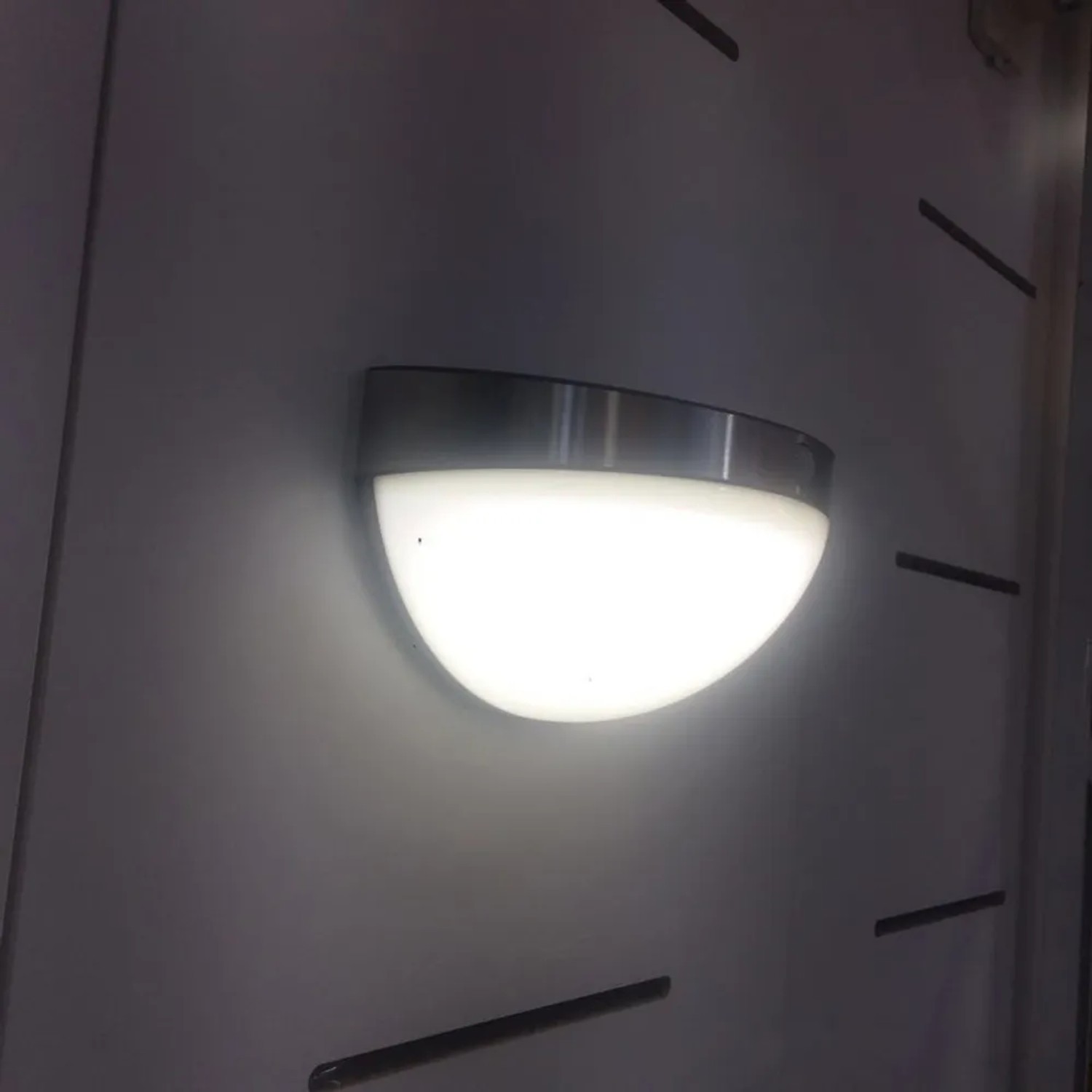 Lutec Solar-Außenwandleuchte Bubble aus Edelstahl, halbkugelförmig und leuchtend.