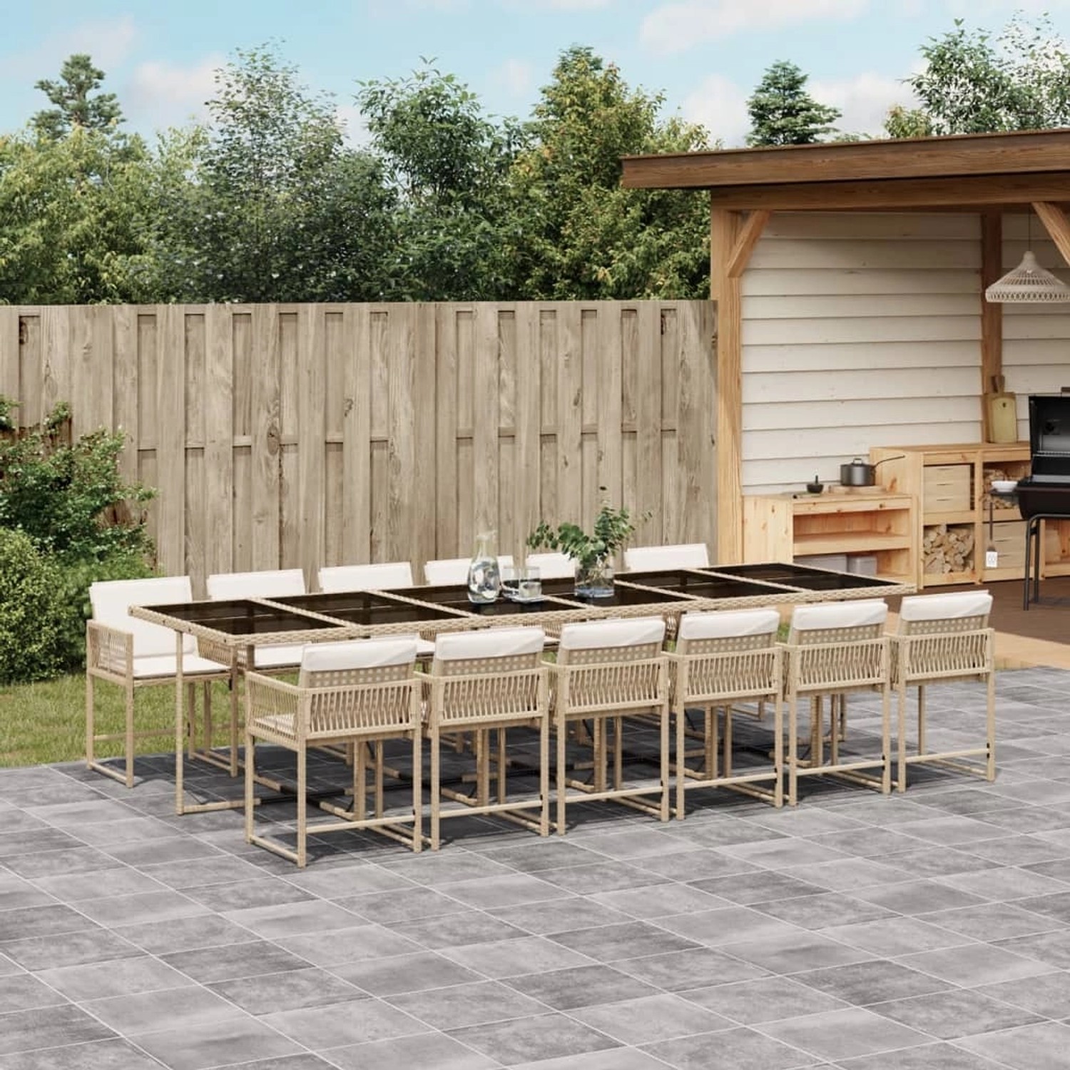 Beige 13-tlg. Garten-Essgruppe aus Poly Rattan mit schwarzen Glasplatten und cremefarbenen Kissen.