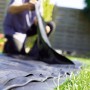 Schwarze Heissner PVC Teichfolie (1 mm) wird im Garten verlegt.