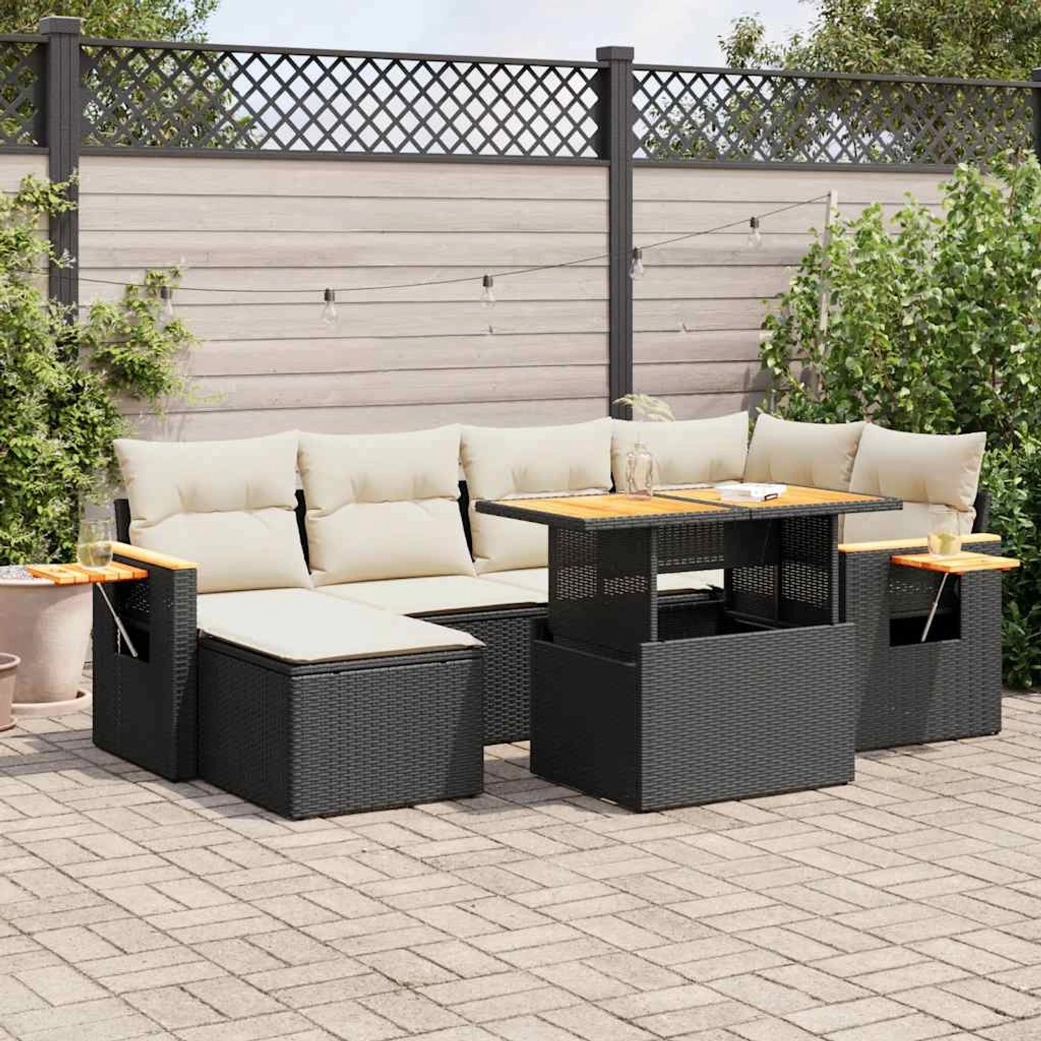 Schwarze 7-tlg. Garten-Sofagarnitur aus Poly Rattan mit cremefarbenen Kissen und Tisch.