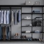 Schwarzer Metall-Drahtgitterboden (60x33x7,2cm) im Regalsystem mit Kleidung und Accessoires.