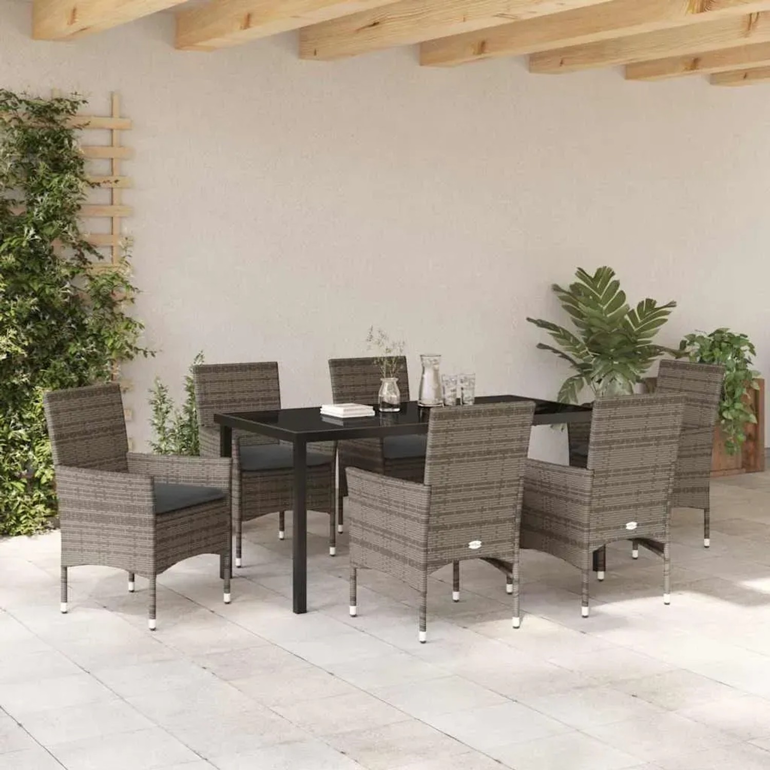 Graue 7-teilige Garten Essgruppe aus Poly Rattan mit Tisch und Stühlen mit Kissen.