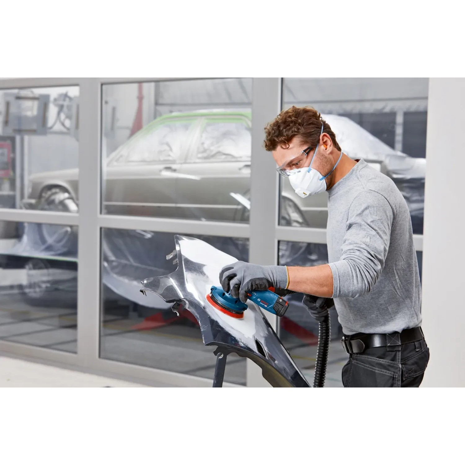 Bosch Professional GEX 12V-125 Akku-Exzenterschleifer beim Schleifen eines Autoteils.