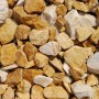 Gold-ockerfarbener Marmorbruch (25-50 mm) im PE-Sack, geeignet für Zierkies- und Splittflächen.