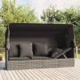 Graues Outdoor-Loungebett mit Dach und Kissen aus Polyrattan für Garten oder Terrasse.