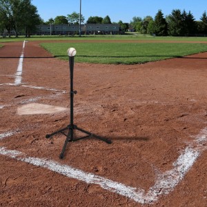 Schwarze Relaxdays Baseball Abschlaghilfe aus Aluminium mit Ball auf Baseballfeld.