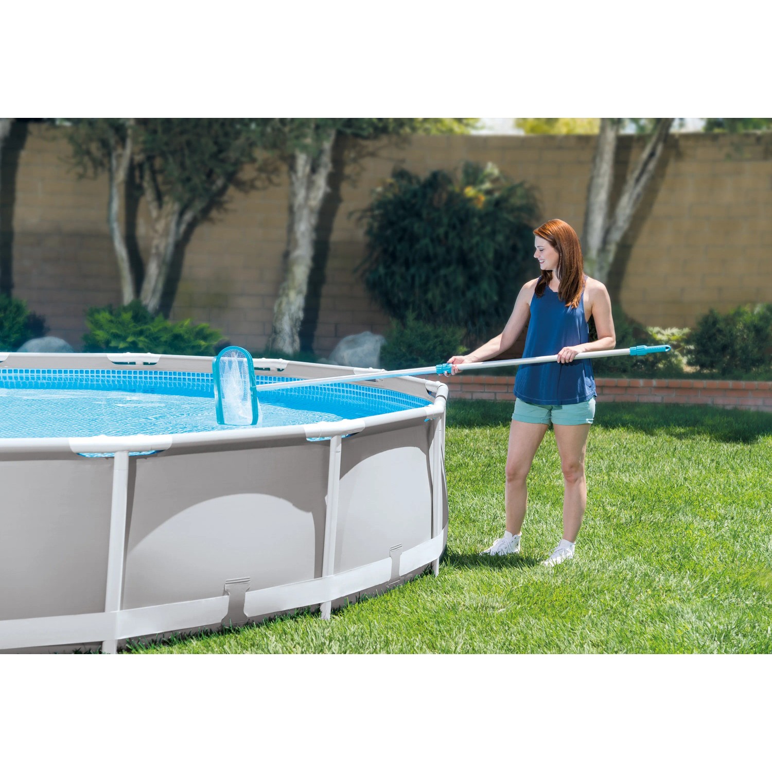 Frau reinigt Pool mit Intex Reinigungs-Set Deluxe, bestehend aus Kescher, Sauger und Teleskopstange.