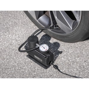 Eufab Mini-Kompressor 12V beim Aufpumpen eines Autoreifens. Kompakter Reifenfüller mit Manometer.