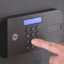Detailaufnahme: Finger tippt auf das Tastenfeld des schwarzen Yale Tresors High Security Safe.