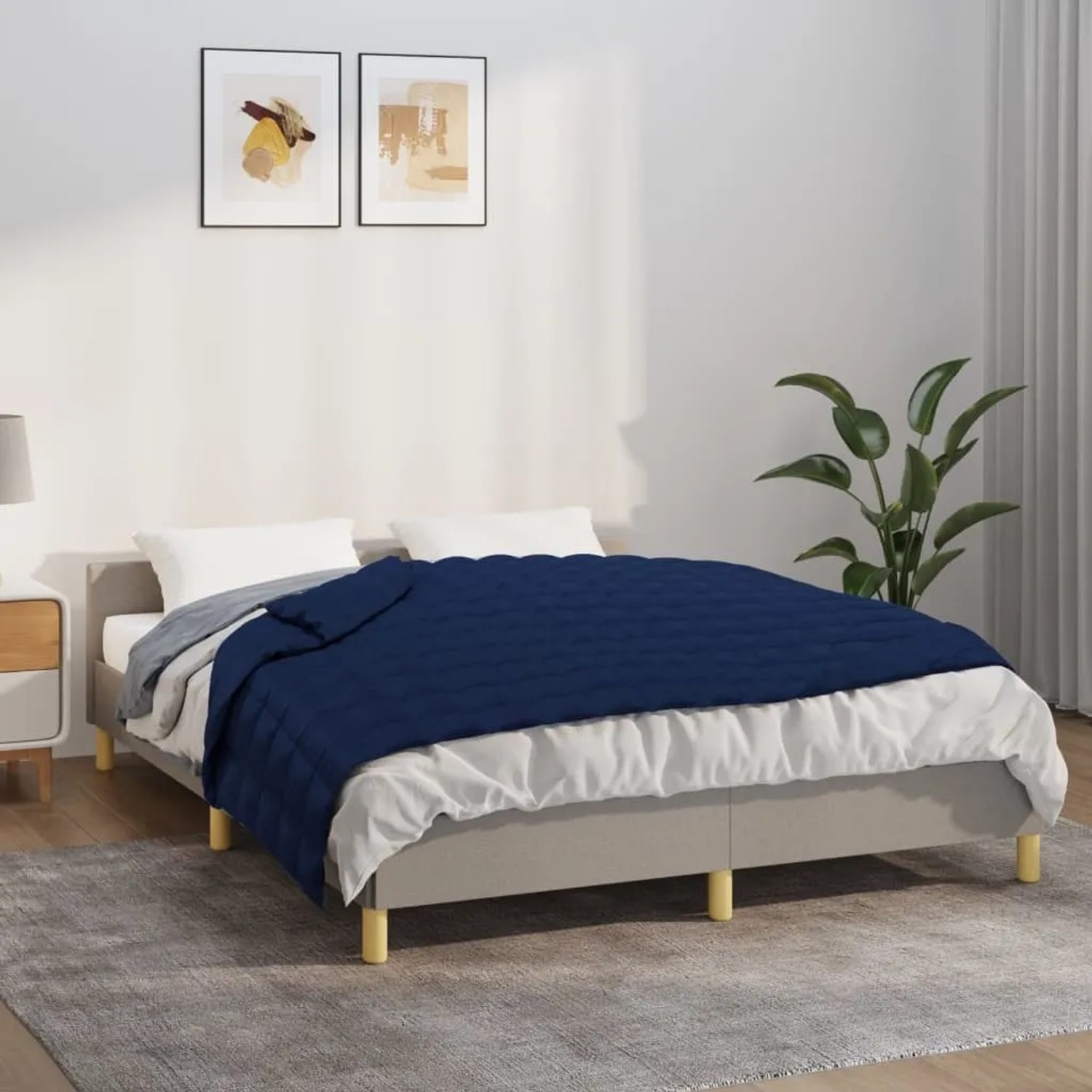 Blau gesteppte Gewichtsdecke (150x200 cm, 7 kg) auf einem Bett. Schlafzimmer-Szene.