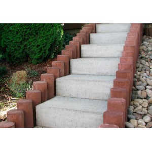 Graue Beton Blockstufe (50x34x15 cm) für Gartentreppen, mit seitlicher Einfassung.