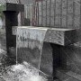 Schwarze Colortree Akustikpaneele als Wandverkleidung mit Wasserfall-Optik.