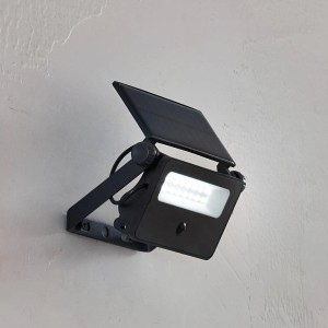 Schwarze Lindby LED Solar-Wandleuchte Rikad mit Bewegungsmelder für den Außenbereich.