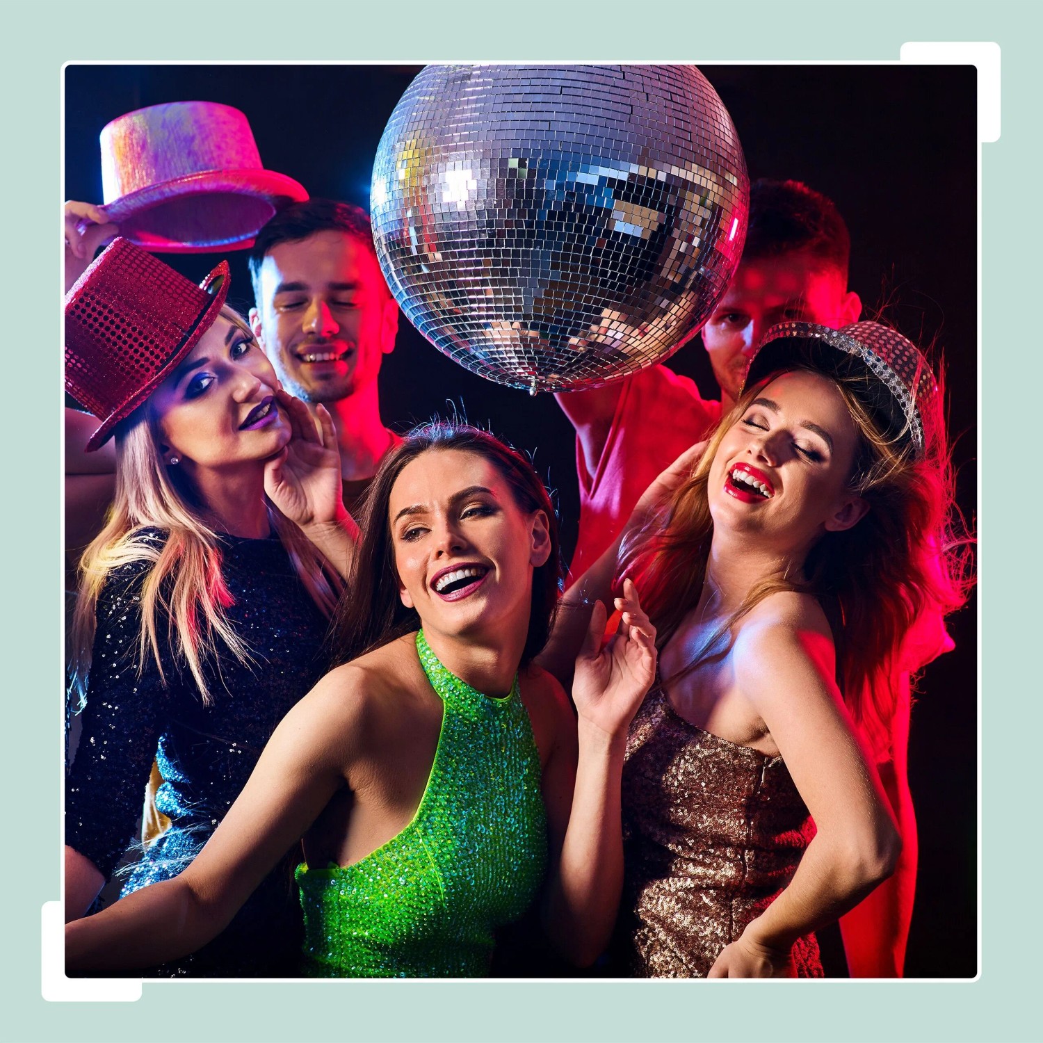 Fröhliche Menschen tanzen unter einer silbernen Discokugel mit bunten Lichtreflexionen auf einer Party.