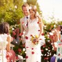 Glückliches Brautpaar unter fallendem Herzkonfetti. Konfettikanone für Hochzeit, Geburtstag & Party.