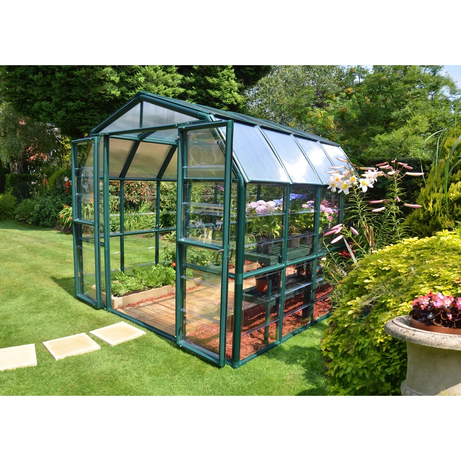 Begehbares, grünes Palram Canopia Gewächshaus mit Fundamentrahmen im Garten.