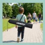Kind trägt faltbares Relaxdays Fußballtor in schwarzer Tragetasche durch Park. Perfekt für Spiel & Spaß.