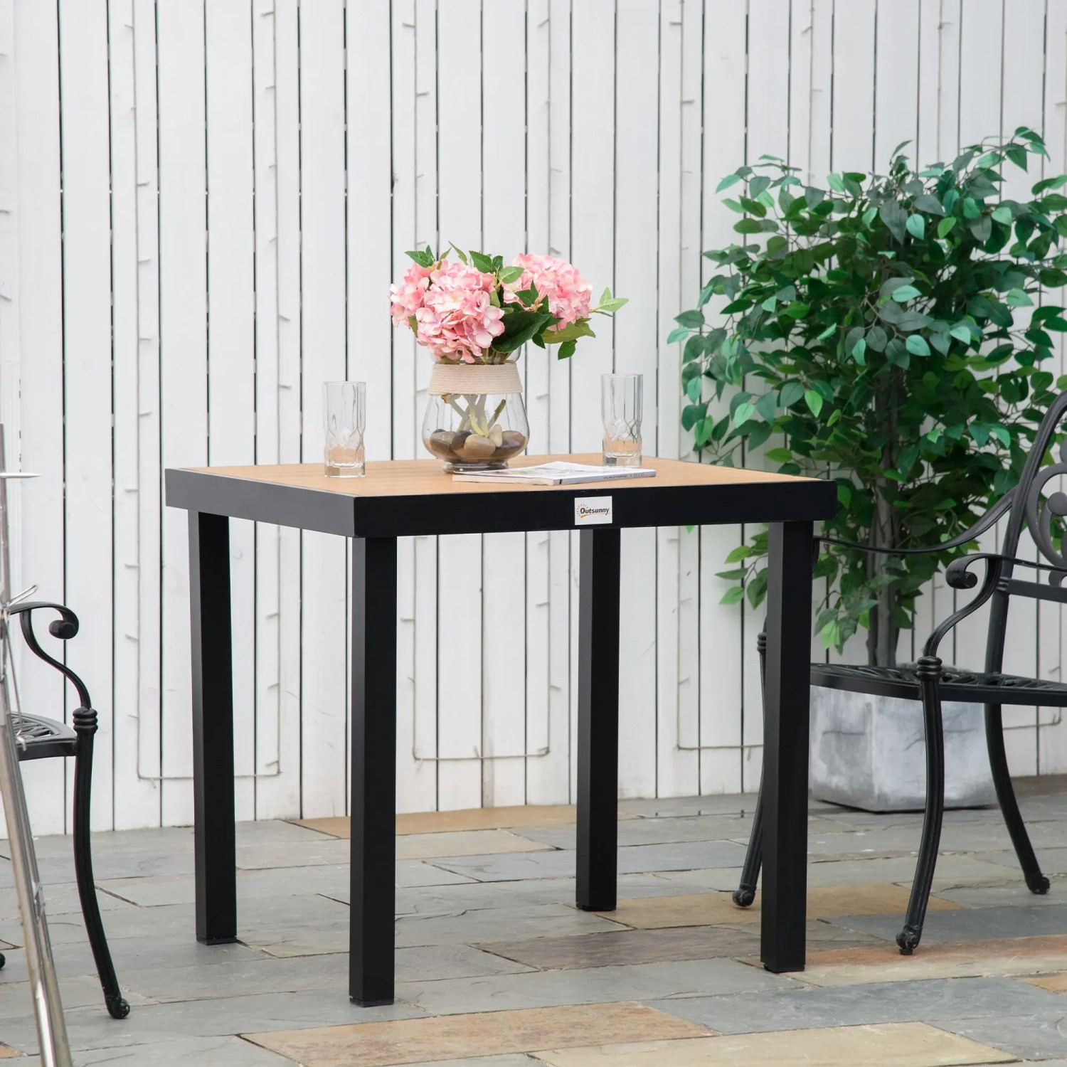 Outsunny Gartentisch für 4 Personen mit Holzoptik und schwarzem Gestell.