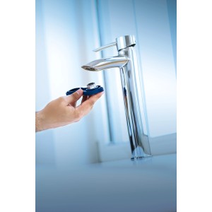 LUX Strahlreglerschlüssel Comfort vor einem Wasserhahn, zur Montage oder Demontage des Strahlreglers.