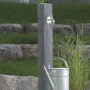 Arves Wasserzapfstelle Natura Black Granit mit Wasserhahn und Gießkanne im Garten.