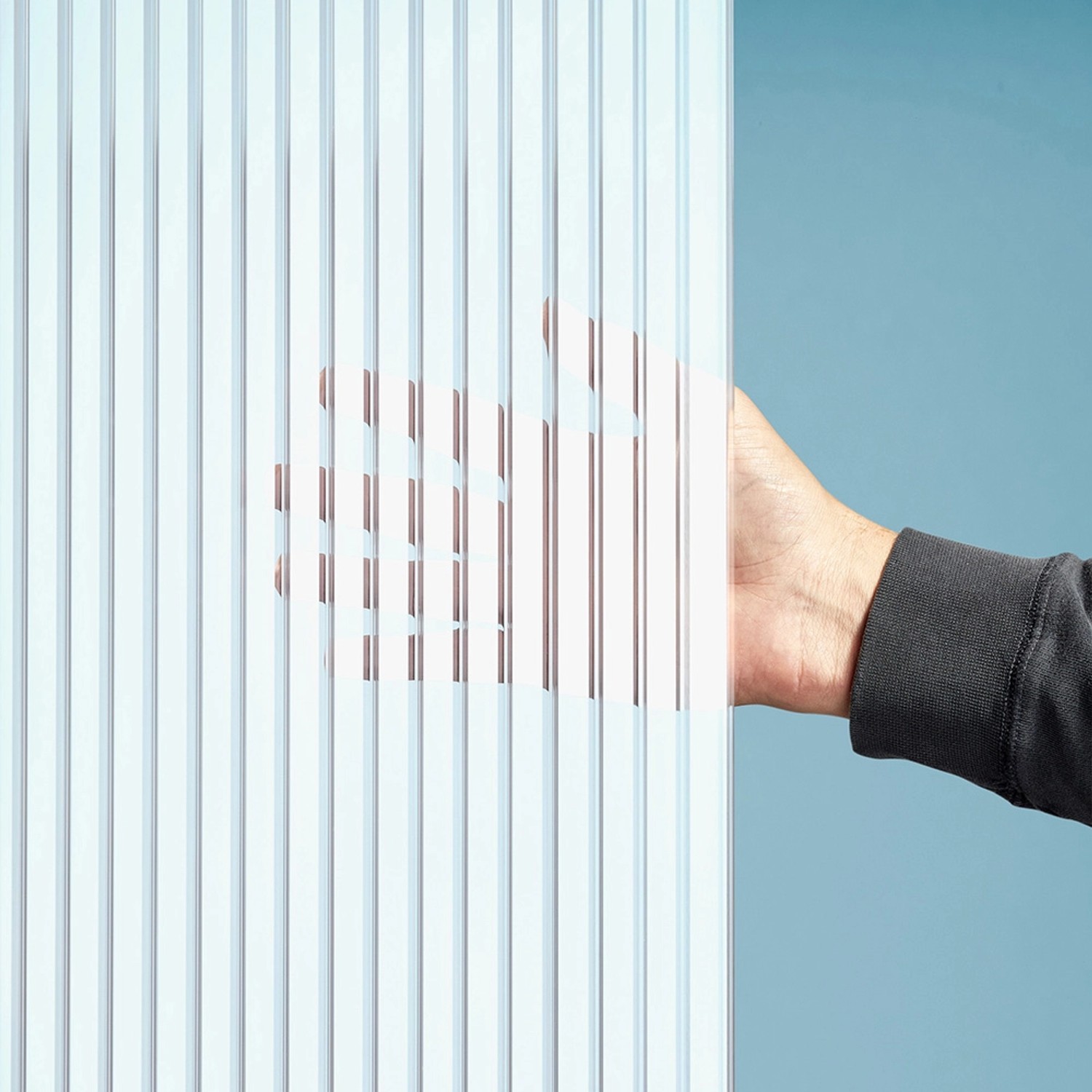 Detailaufnahme: Gutta Terrassendach Premium Stegplatte PC Streifen Weiß, Hand berührt Platte.