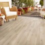 Heller Kaindl Laminatboden CMI 6 mm Eiche Levi in Wohnraum-Szene mit Sessel und Dekoration.