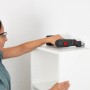 Frau schraubt mit Bosch Akku-Bohrschrauber AdvancedDrill 18V-80 Solo einen Schrank an die Wand.
