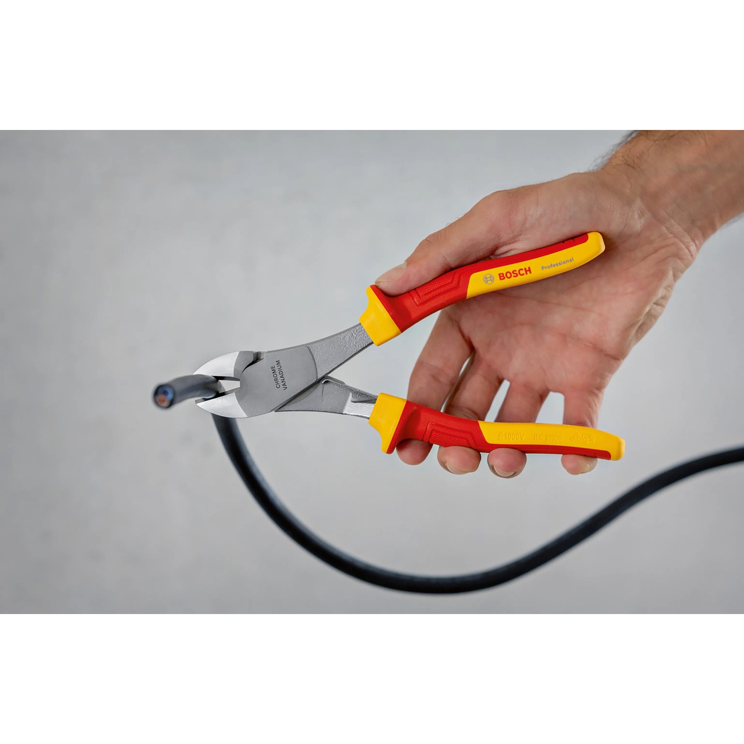 Bosch Professional VDE-Seitenschneider (200 mm) schneidet ein schwarzes Kabel.