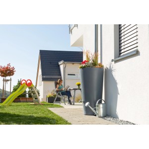 Graue Arves Regentonne Rainbowl Flower 150 l mit Bepflanzung und Gießkanne im Garten.
