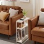 Schmaler, weißer Songmics Nachttisch Barnet-old mit Ladefunktion neben Sofa.