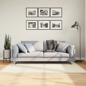 Beiger, quadratischer Kurzflor-Teppich OVIEDO (120x120 cm) auf Holzfußboden im Wohnzimmer.