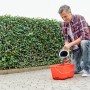 Mann mischt Ultrament Betonlasur Pflaster Frisch Grau in einem roten Eimer für die Anwendung.