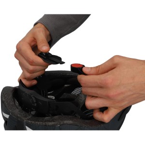 Detailaufnahme: Hände schließen den Kinnriemen des Fischer Fahrradhelm Urban Plus Brooklyn L/XL.