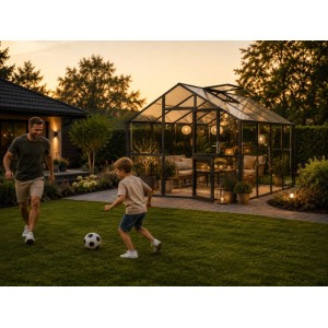 Modernes KGT Gewächshaus Ortasia IV Anthrazit-Grau als Gartenlounge im Abendlicht, Familie spielt im Garten.