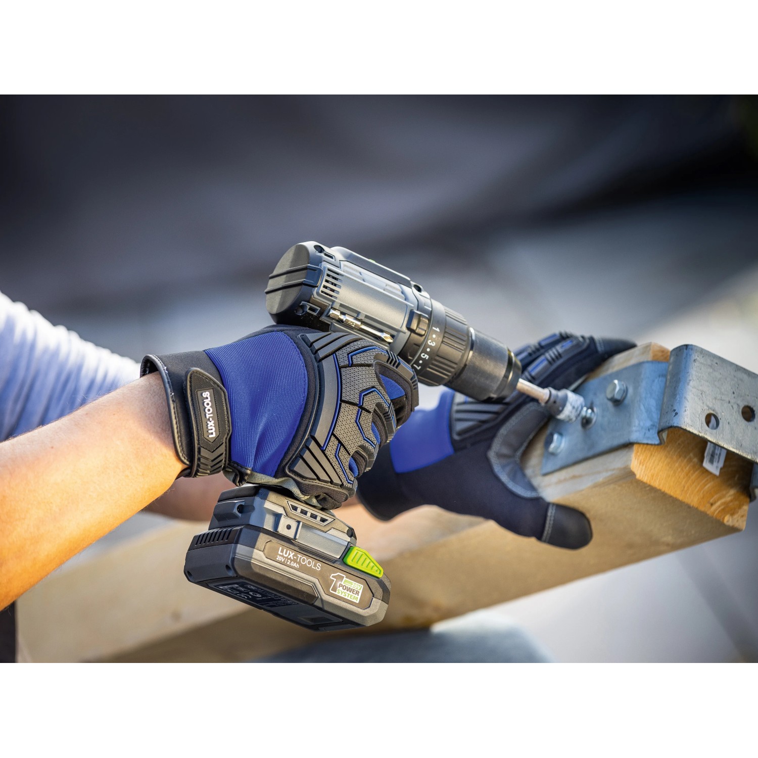 Mann mit LUX Arbeitshandschuhen Men Strong Protect Gr. 8 bohrt Schraube ein.