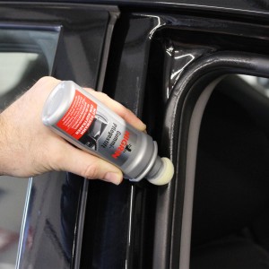 Anwendung des Nigrin Gummi-Pflegestifts auf einer Autotürdichtung.