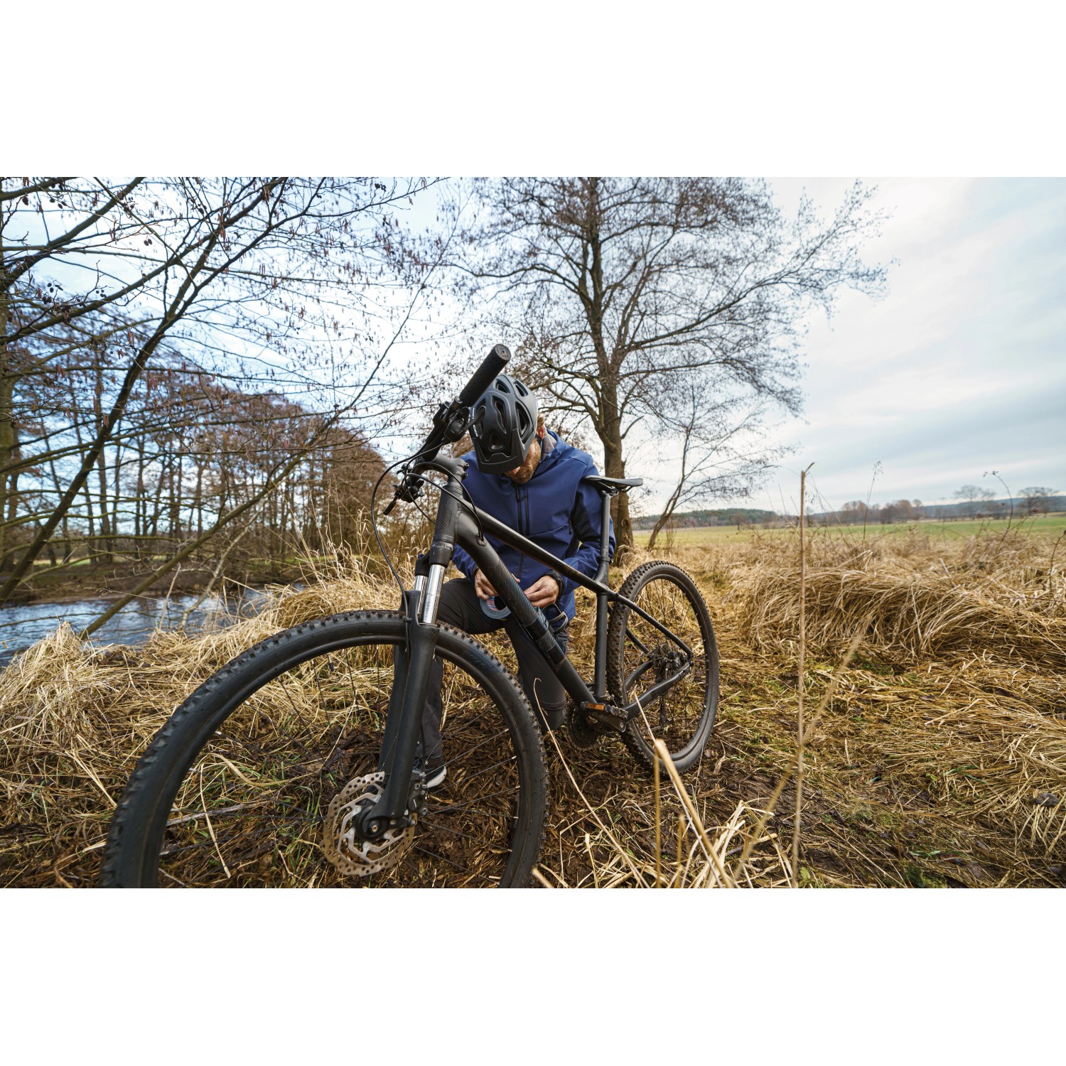 Mann repariert Fahrrad mit Tesa Reparaturband Ultra Power Extreme im Outdoor-Bereich.