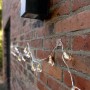 Lichterkette mit Tesa Universal-Klebeband an einer Backsteinmauer befestigt.