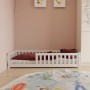 Weißes Juskys Kinderbett Naya 90x200 cm mit Rausfallschutz und Lattenrost im Kinderzimmer.