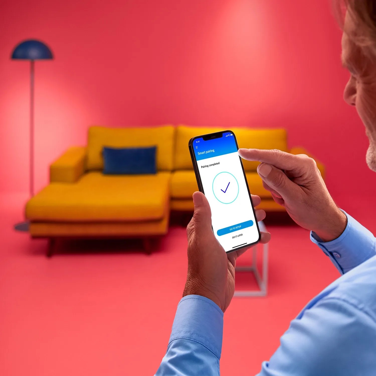 Mann steuert WiZ LED Deckenleuchte per App. Smarte Lampe mit Tunable White Funktion.