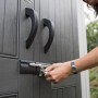 Detailaufnahme: Frau schließt ein Lifetime Kunststoff-Gartenhaus Stella mit Schlüssel auf.