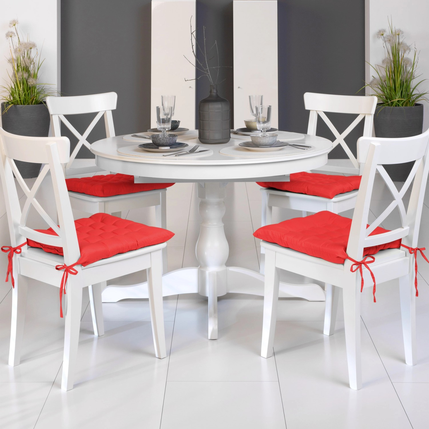 4 rote Beautissu Stuhlkissen Lea 40x40 cm auf weißen Stühlen am Esstisch.
