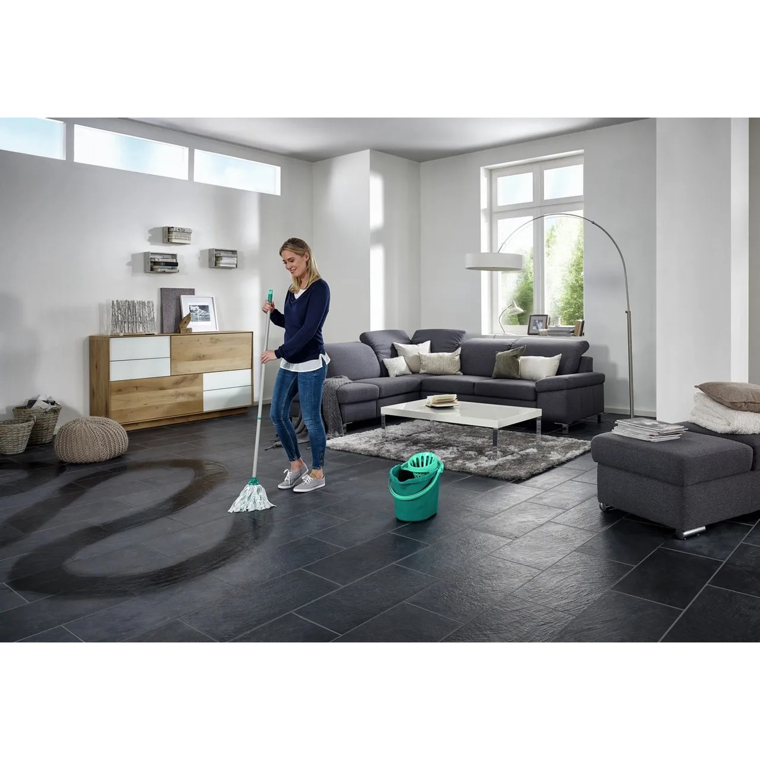 Frau wischt mit dem Leifheit Wischmop-Set Classic den Boden im Wohnzimmer.