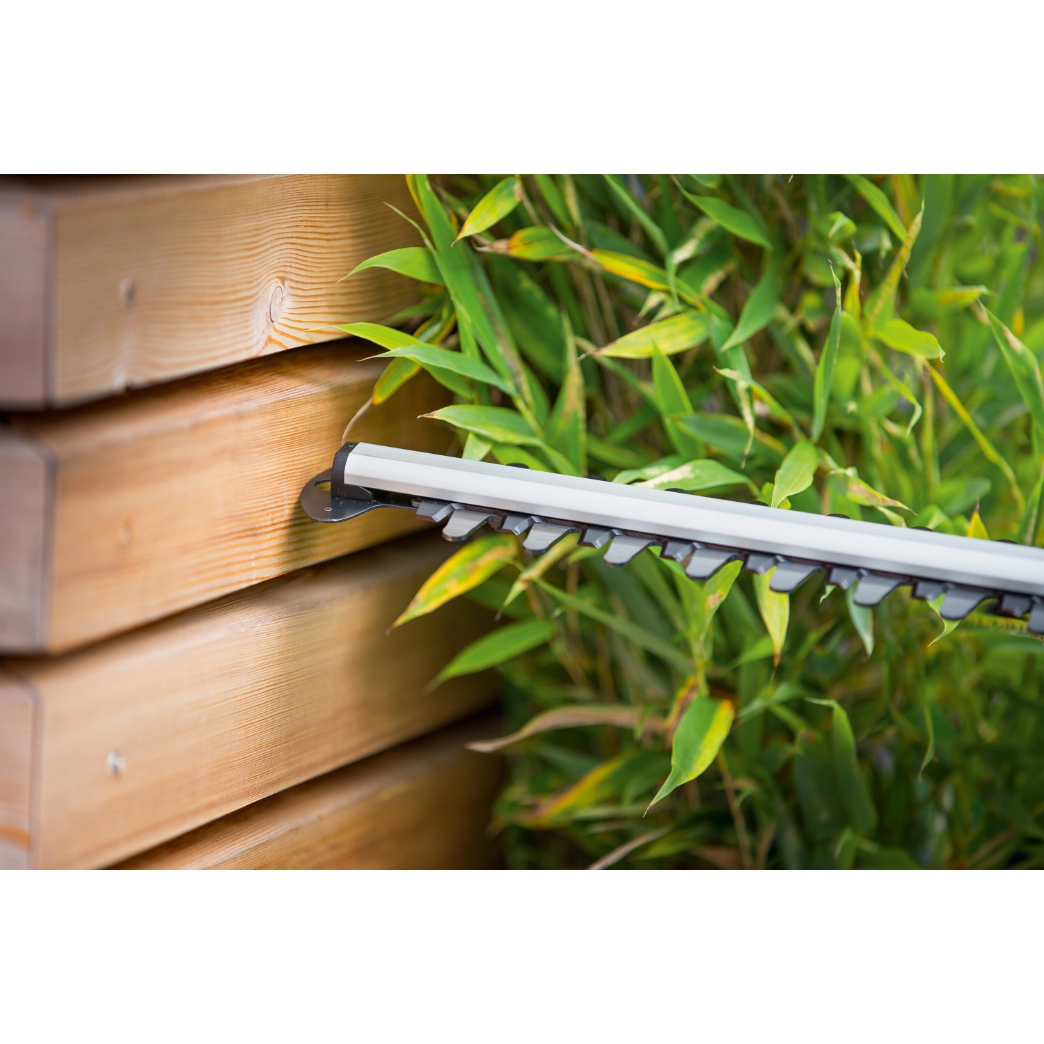 Detailaufnahme der LUX Elektro-Heckenschere E-HS-600/55 A beim Schneiden einer Hecke.