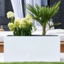 Weißer Vivanno Pflanzkübel Maxi (100x45x45 cm) mit Pflanzen im Garten.