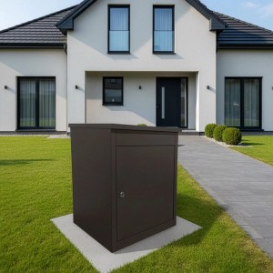 Schwarze Relaxdays Paketbox aus pulverbeschichtetem Eisen, 56 cm hoch, abschließbar, vor modernem Haus auf Rasen.