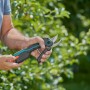 Gardena Assistcut Akku Gartenschere in Aktion, für müheloses Schneiden von Ästen im Garten.