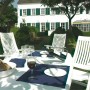 Weiße Kettler ROMA Multipositionssessel aus Kunststoff an Gartentisch mit Wein und Brot. Gartenmöbel für entspannte Stunden.